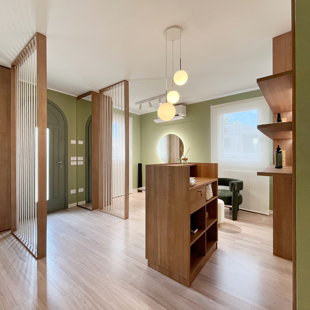 immagine della reception del salone con bancone in legno e dietro muro color salvia